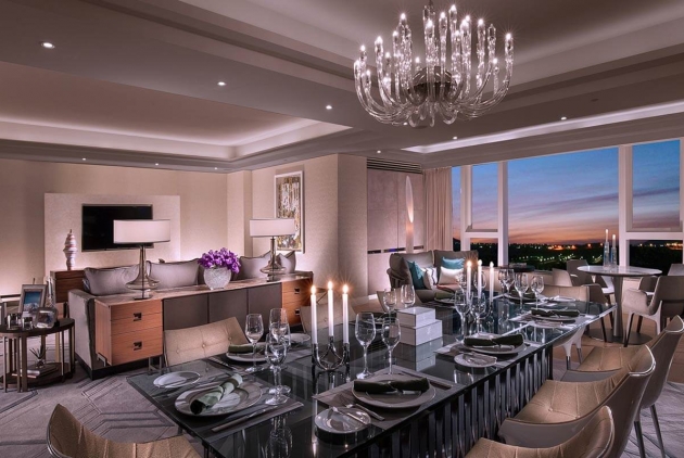 A luxury suite with a chandelier and a large table set for a meal