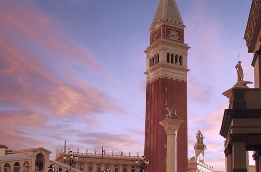 A tall tower with a pink and blue sky in the background