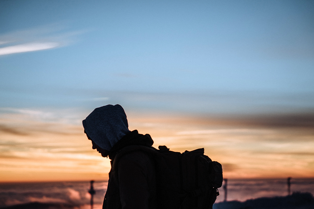 silhouette of a person carrying a backpack